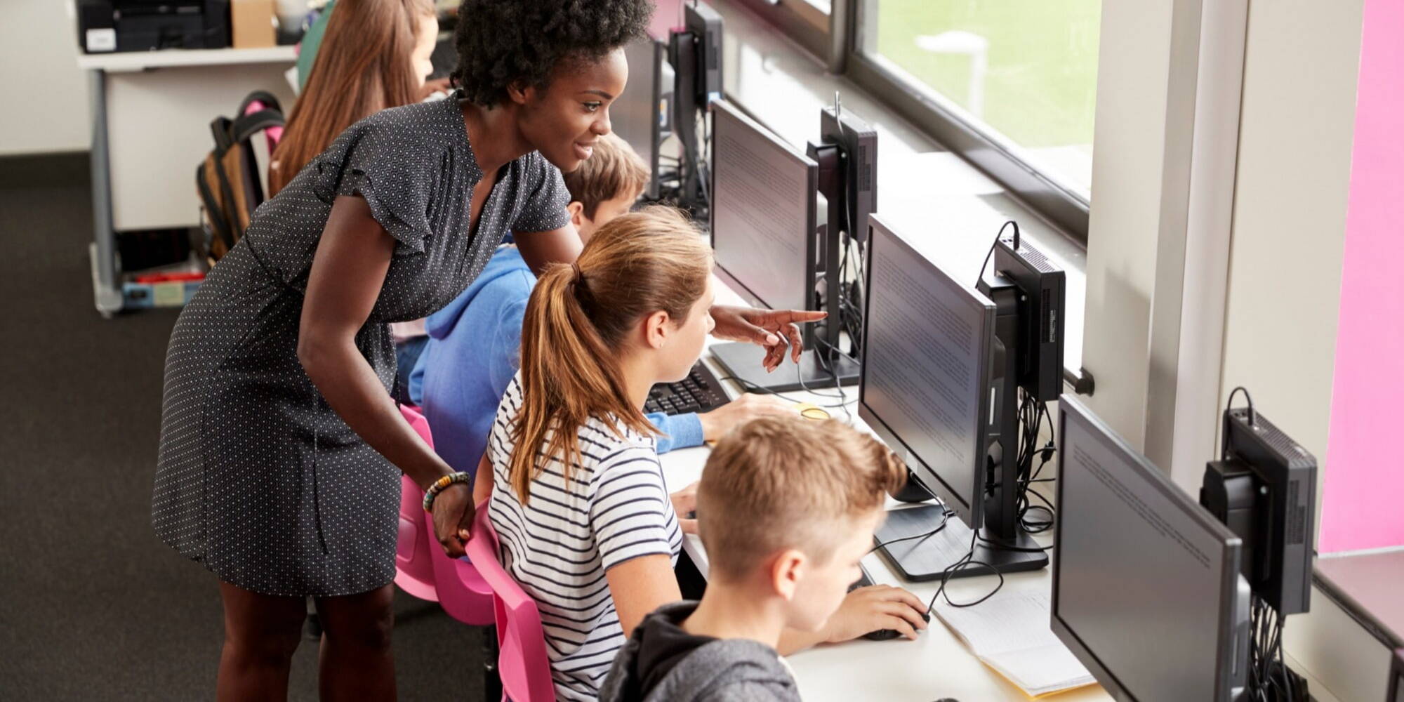 Teacher helping student on their computer