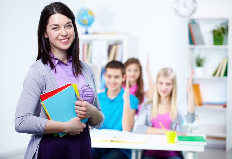 Happy teacher with her students in the background